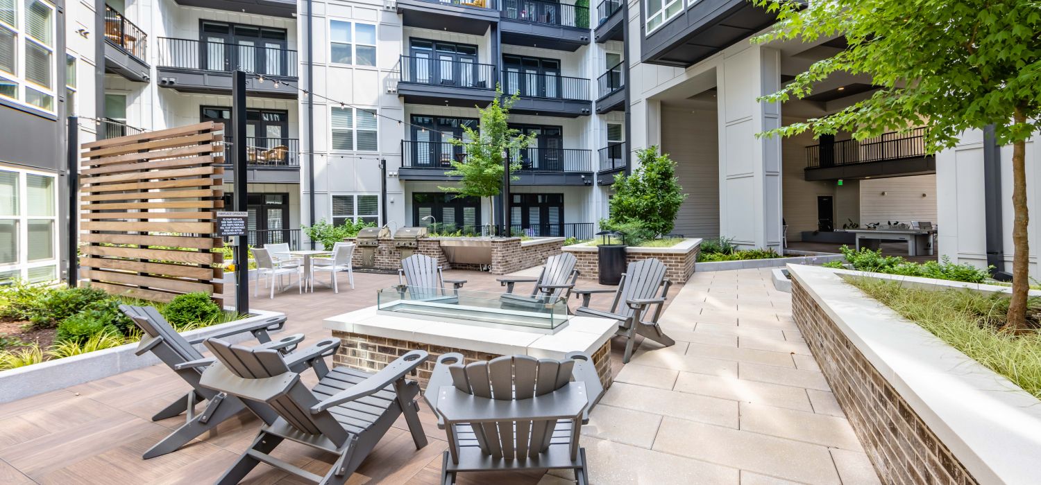 500 West Trade luxury apartments building building exterior community amenities rooftop pool deck outdoor lounge area with couches, a fireplace, and a TV