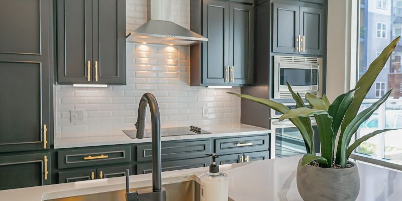 500 West Trade luxury apartment kitchen with island, cabinets, living room with couch, chair, and large windows with natural light