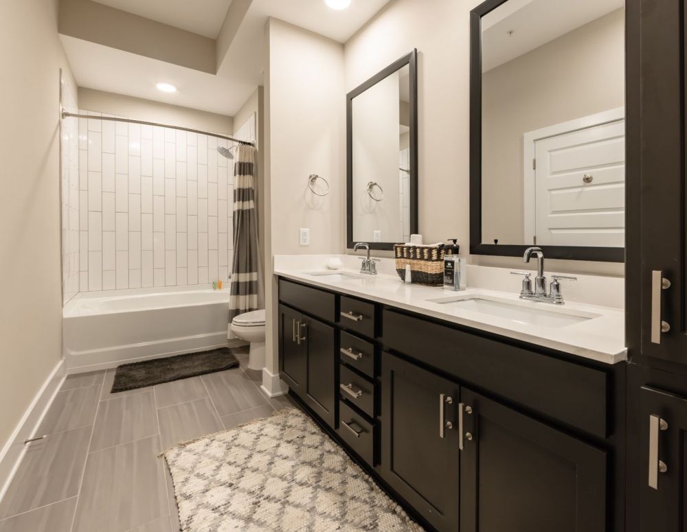 500 West Trade luxury apartment kitchen with island, bar stools, custom cabinets, and faux wood flooring