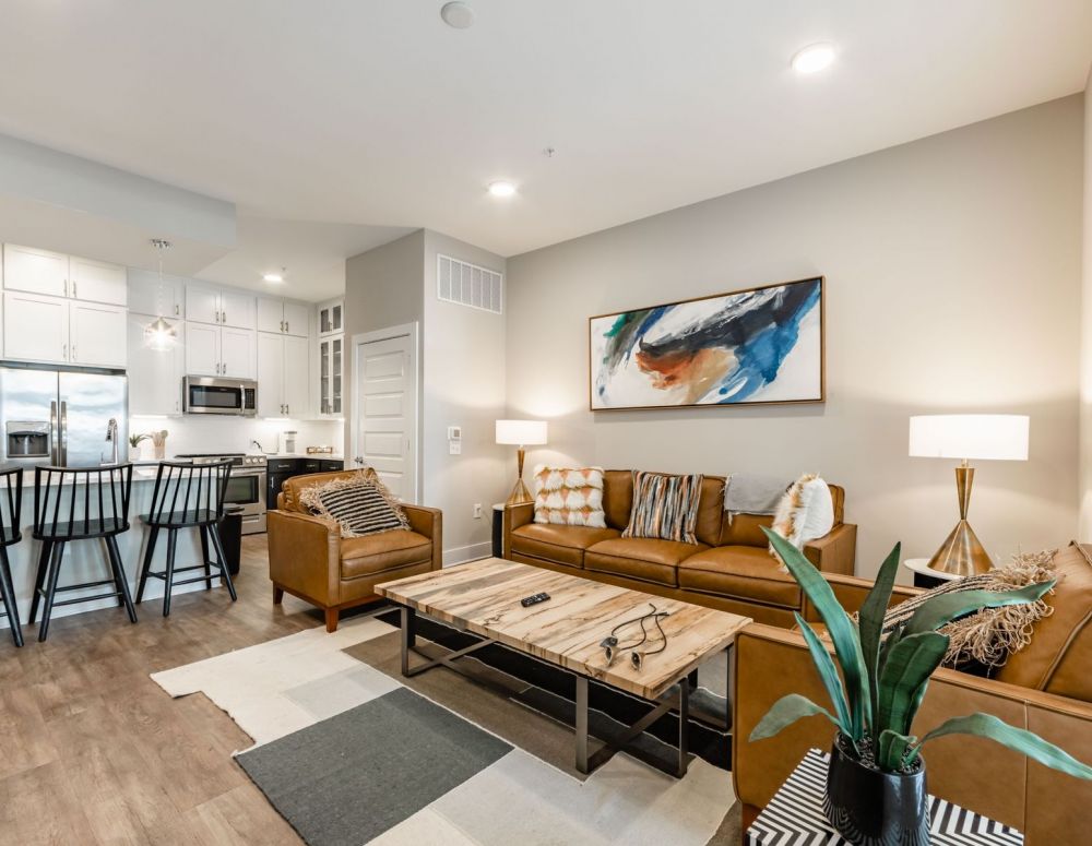 500 West Trade luxury apartment kitchen with island, bar stools, custom cabinets, and faux wood flooring