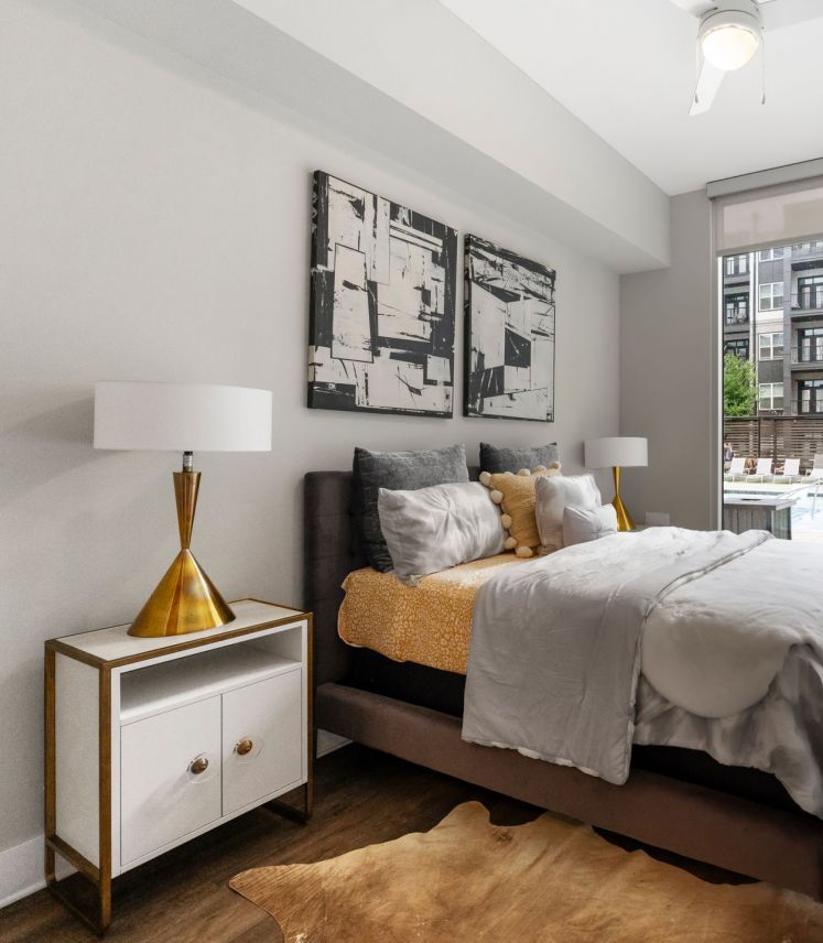 500 West Trade luxury apartment living room with couch, coffee table, rug, faux wood flooring and large windows with nice natural light