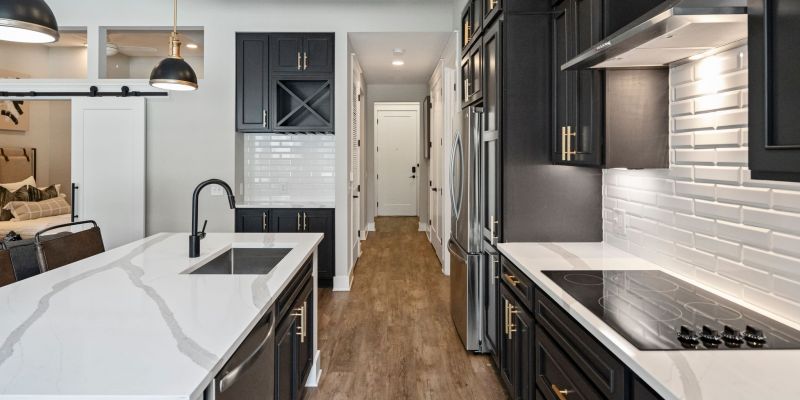 500 West Trade luxury apartment kitchen with island, cabinets, living room with couch, chair, and large windows with natural light