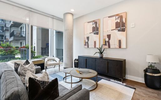 500 West Trade luxury apartment kitchen with island, bar stools, and living room
