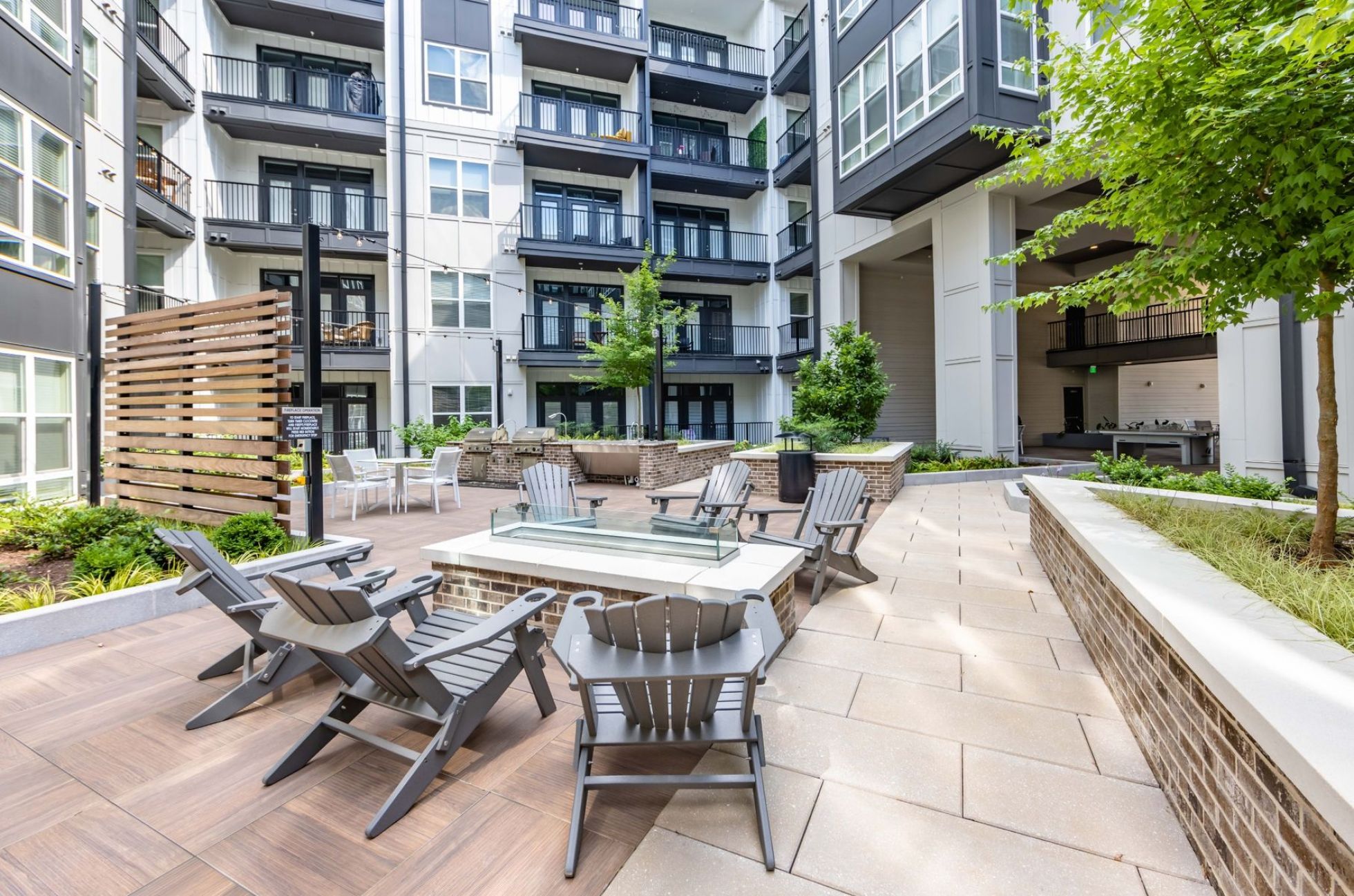 500 West Trade Apartment building exterior courtyard and sitting space with fire pit