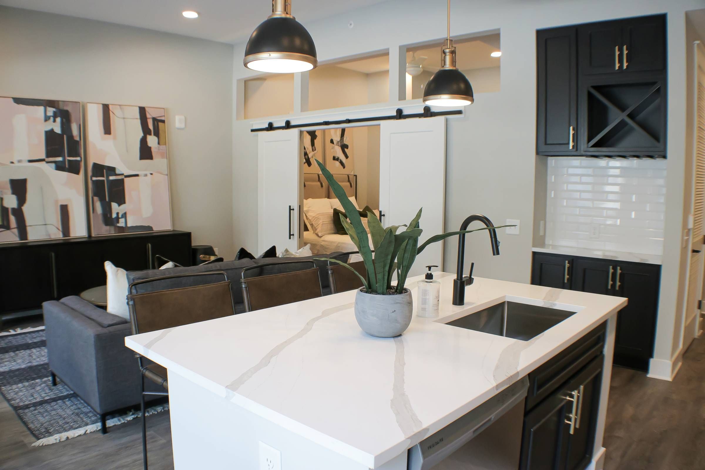 500 West Trade luxury apartment kitchen with island, bar stools, and living room