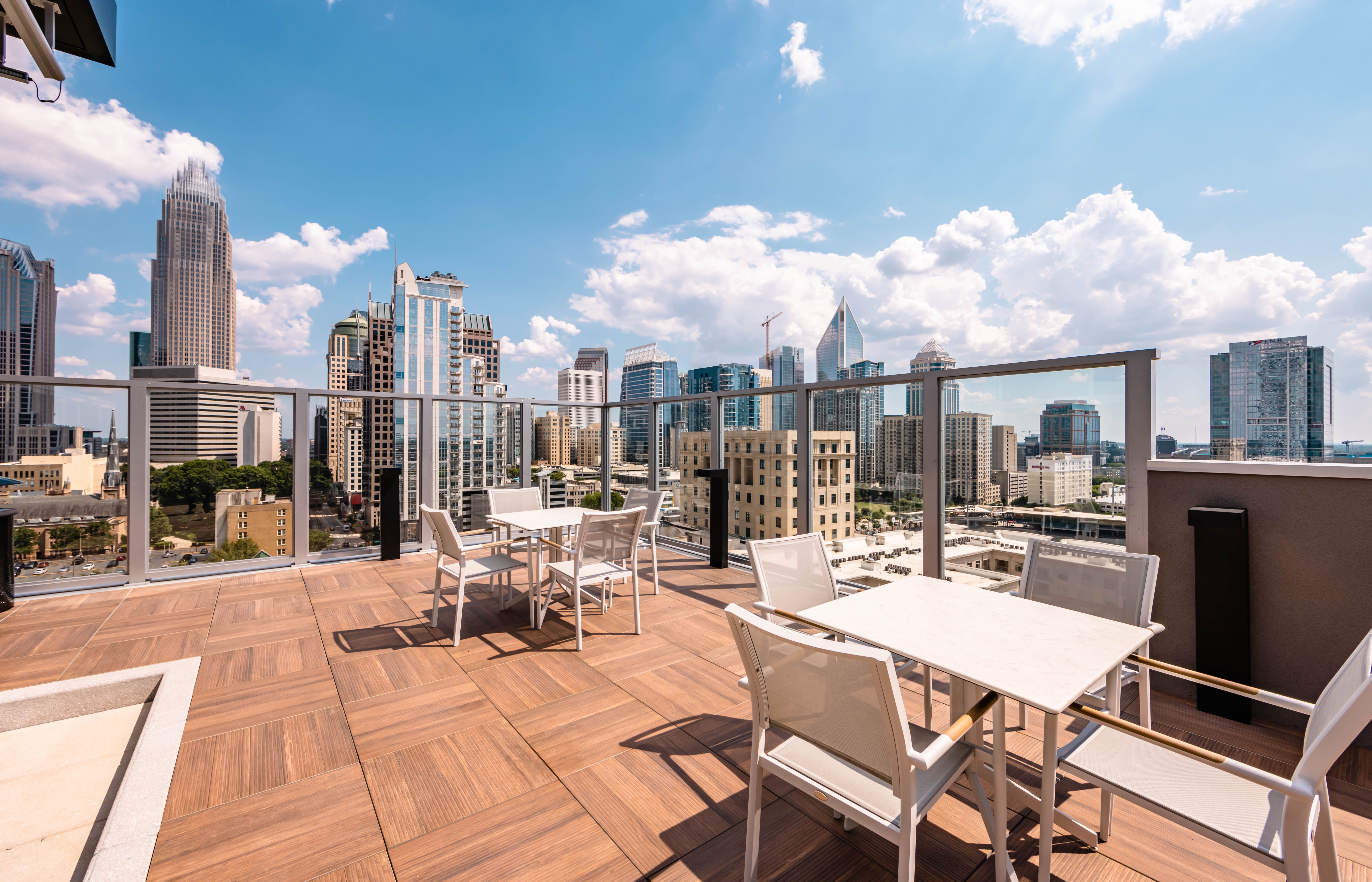 500 West Trade luxury apartments building exterior community amenities rooftop pool and hot tub with beautiful view of the city line and skyscrapers
