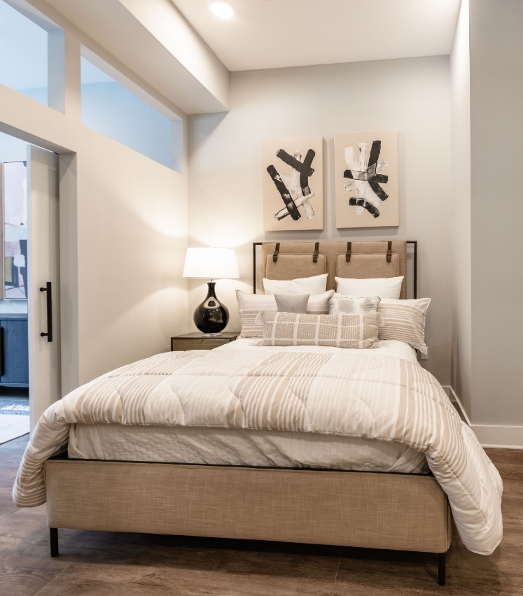 500 West Trade luxury apartment bedroom with bed, faux wood flooring, large closet, nice light, and wall art