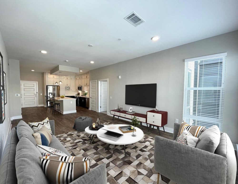 500 West Trade luxury apartment kitchen with island, bar stools, custom cabinets, and faux wood flooring