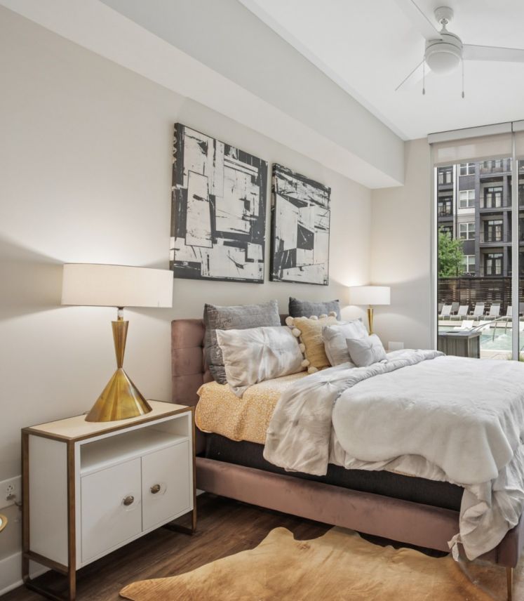 500 West Trade luxury apartment living room with couch, coffee table, rug, faux wood flooring and large windows with nice natural light